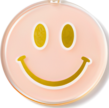 peach colored key chain with a smiley face design on a white background